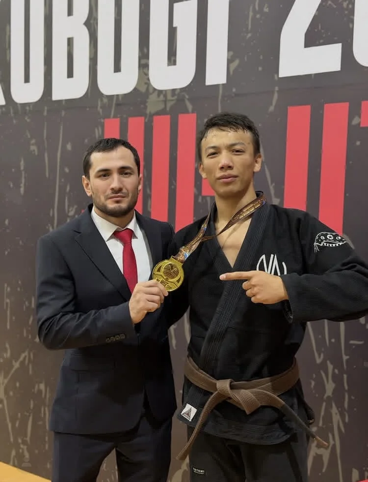 Head coach of Kaizen Jiu Jitsu Academy with a champion's gold medal